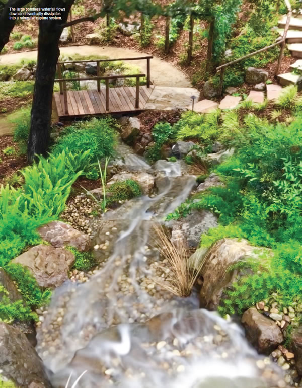 The large pondless waterfall flows down and eventually dissipates into a rainwater capture system).