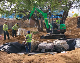 The team completes the
excavation of the large pondless basin-rainwater capture system.
